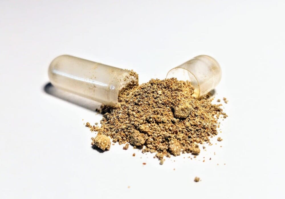 Ashwagandha powder spilling out of a capsule