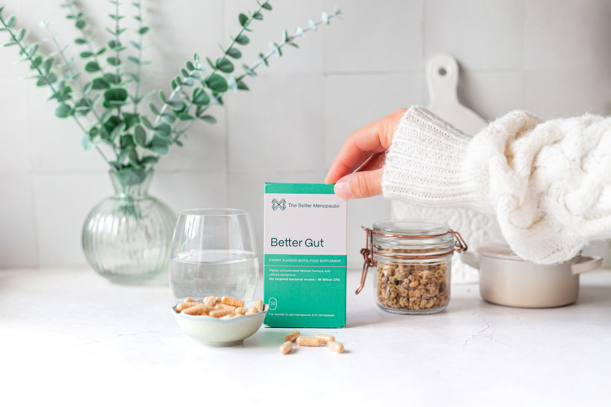 Better Gut on a kitchen counter with a glass of water, capsules and a jar of granola